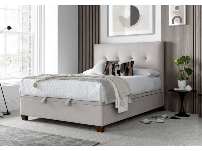 Luxurious pale cream fabric ottoman bed frame with modern dark wooden feet.