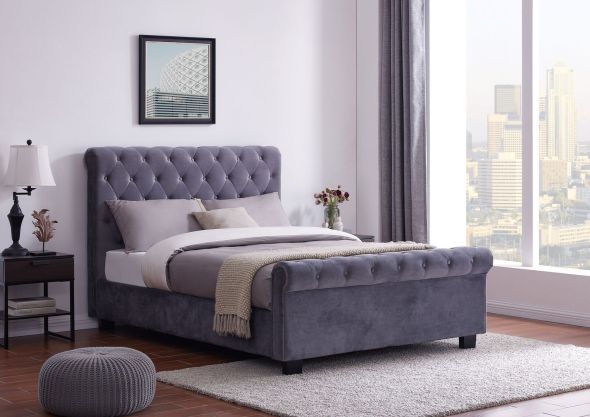 An elegant Chesterfield style ottoman bed frame upholstered in a plush grey fabric.