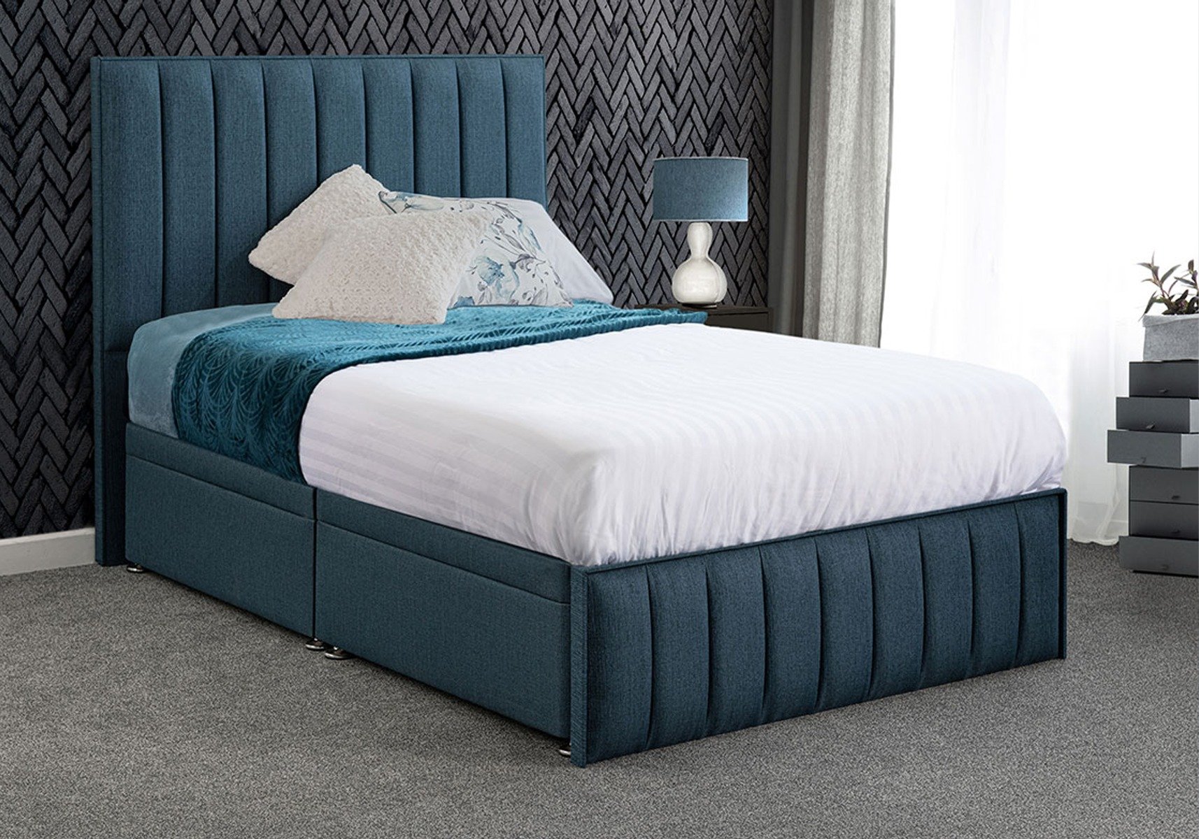 Blue small double ottoman bed with white and blue bedsheets, and beige pillows