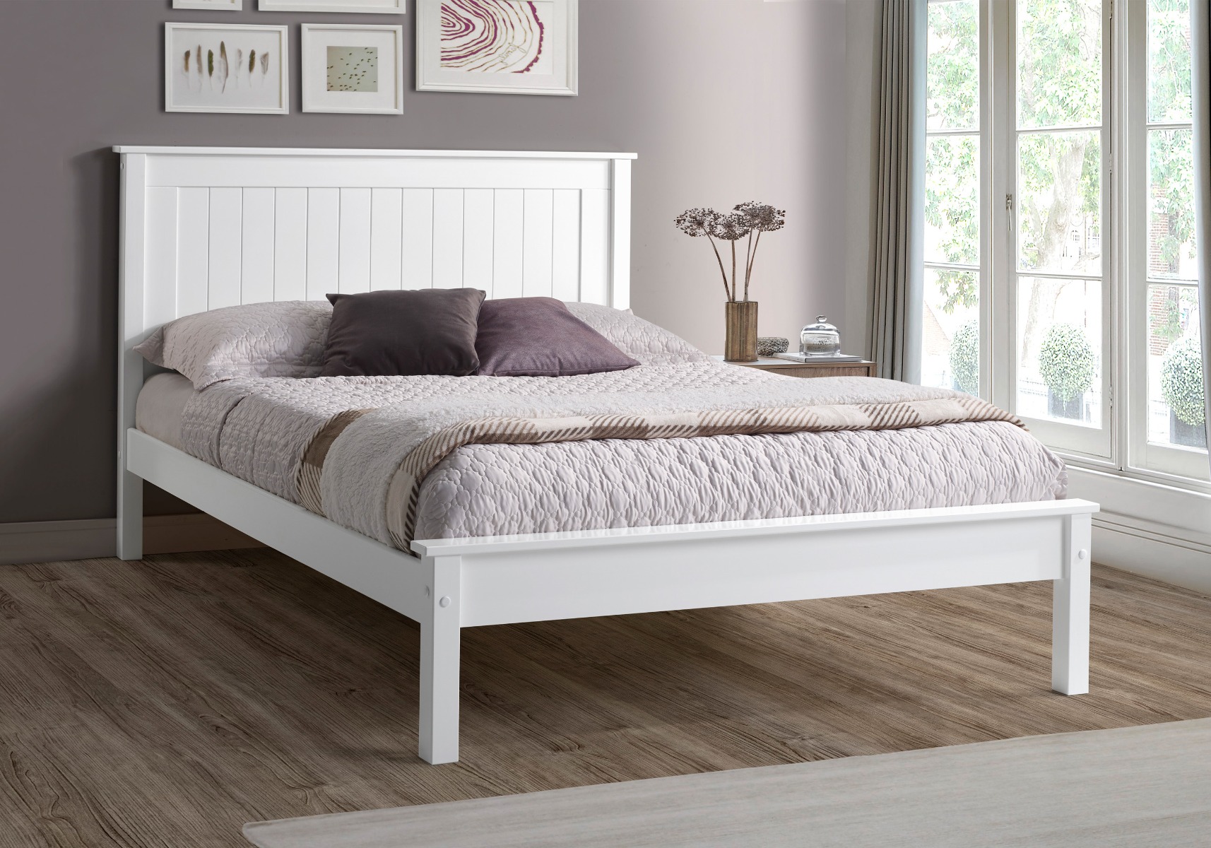 White wooden double bed with purple, brown and grey bedsheets